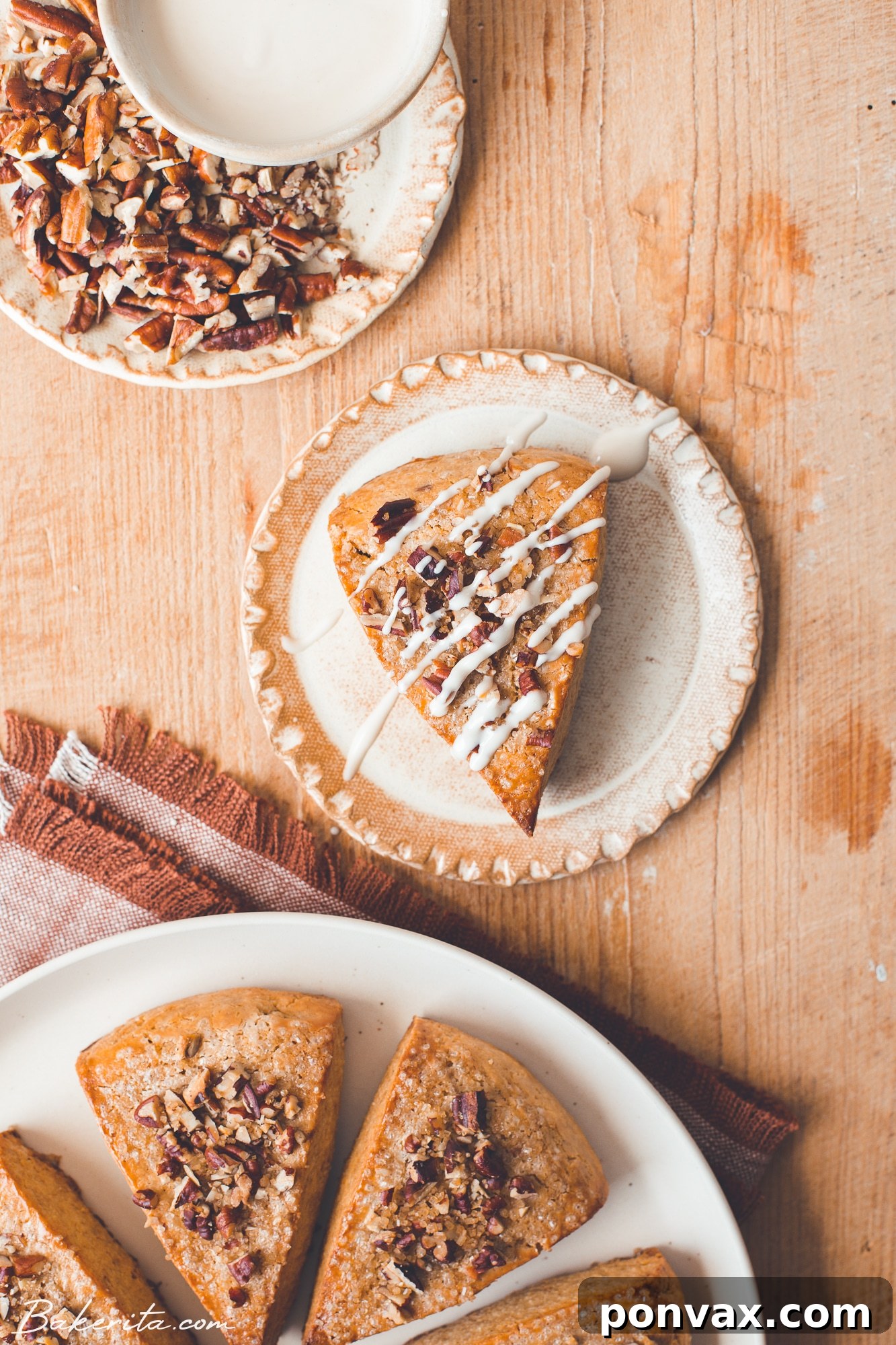 A close-up shot of a single Gluten-Free Vegan Pumpkin Scone on a wire rack, beautifully glazed and garnished.