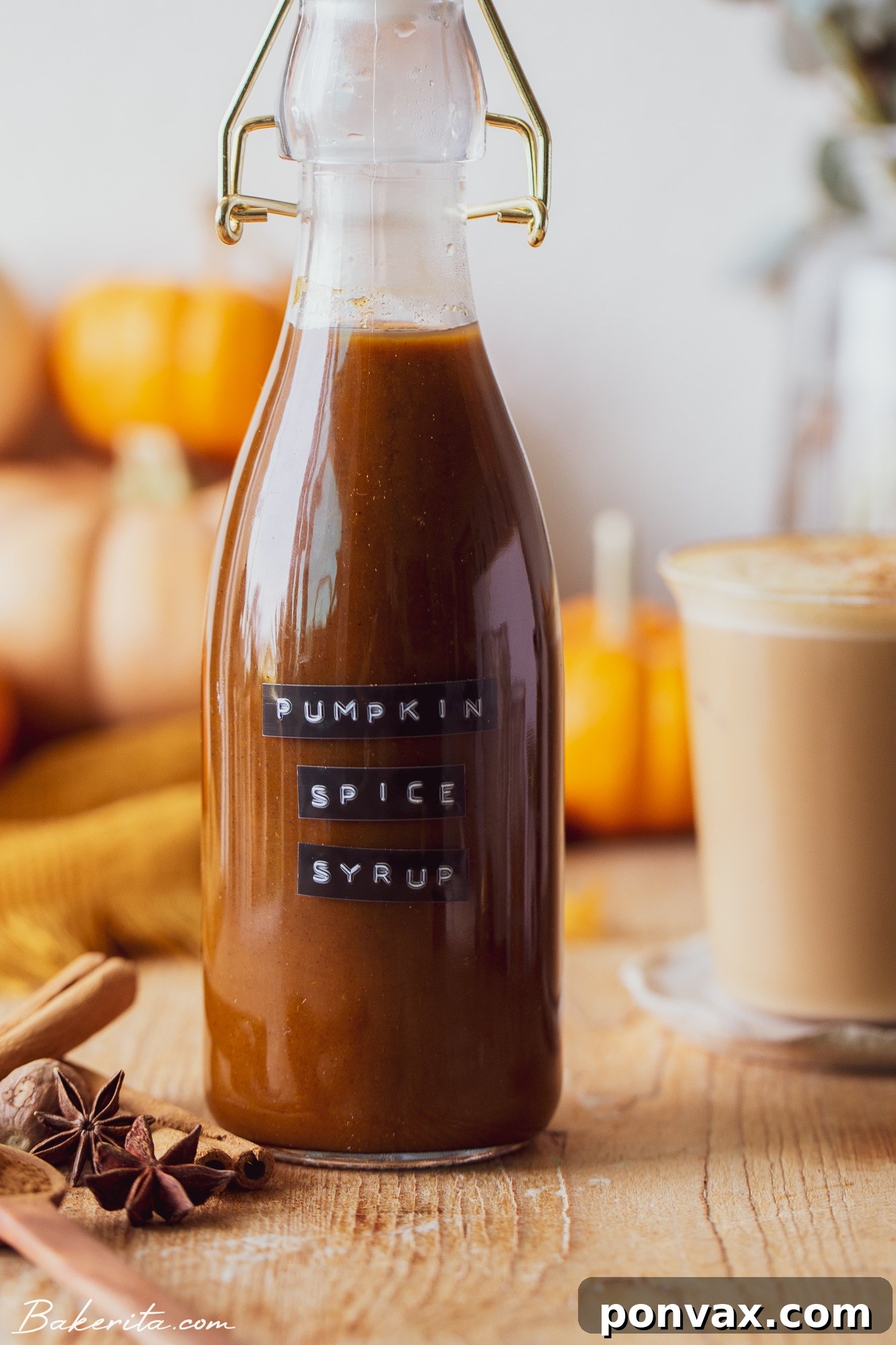 Pumpkin spice syrup poured into a glass with ice and milk.