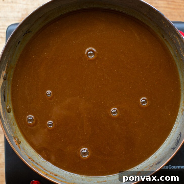 Maple syrup, coconut sugar, and water added to pumpkin and spices in a saucepan.