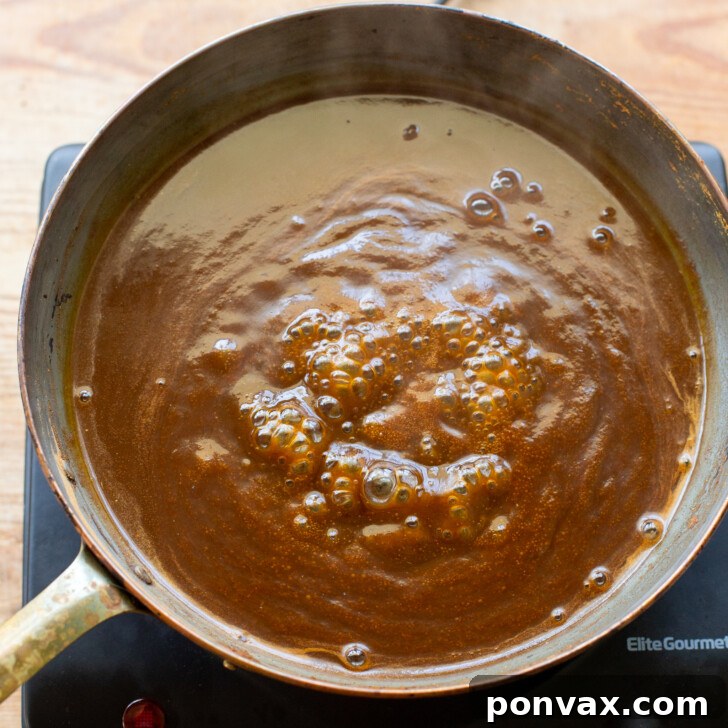 Pumpkin spice syrup simmering in a saucepan.