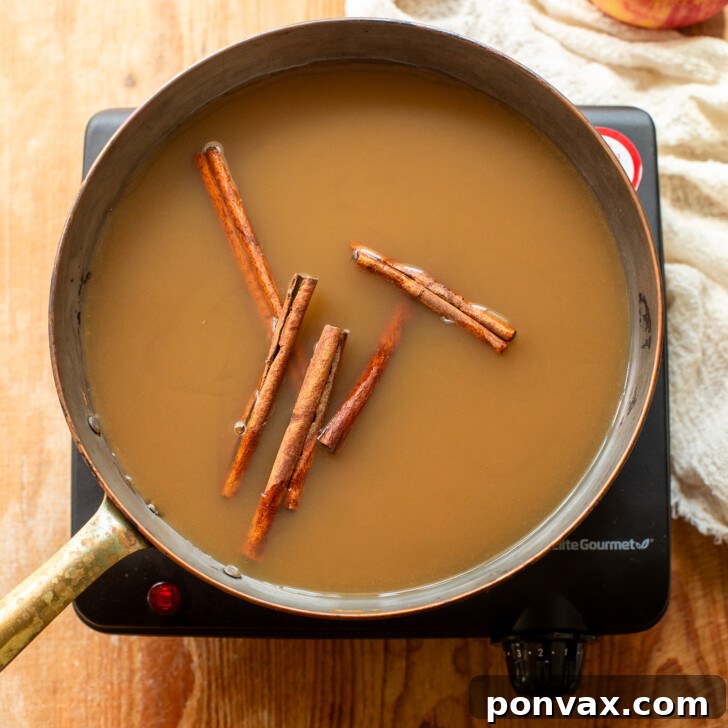 Whip Up Your Own Apple Syrup 4 Cinnamon sticks added to the apple syrup mixture in the saucepan.