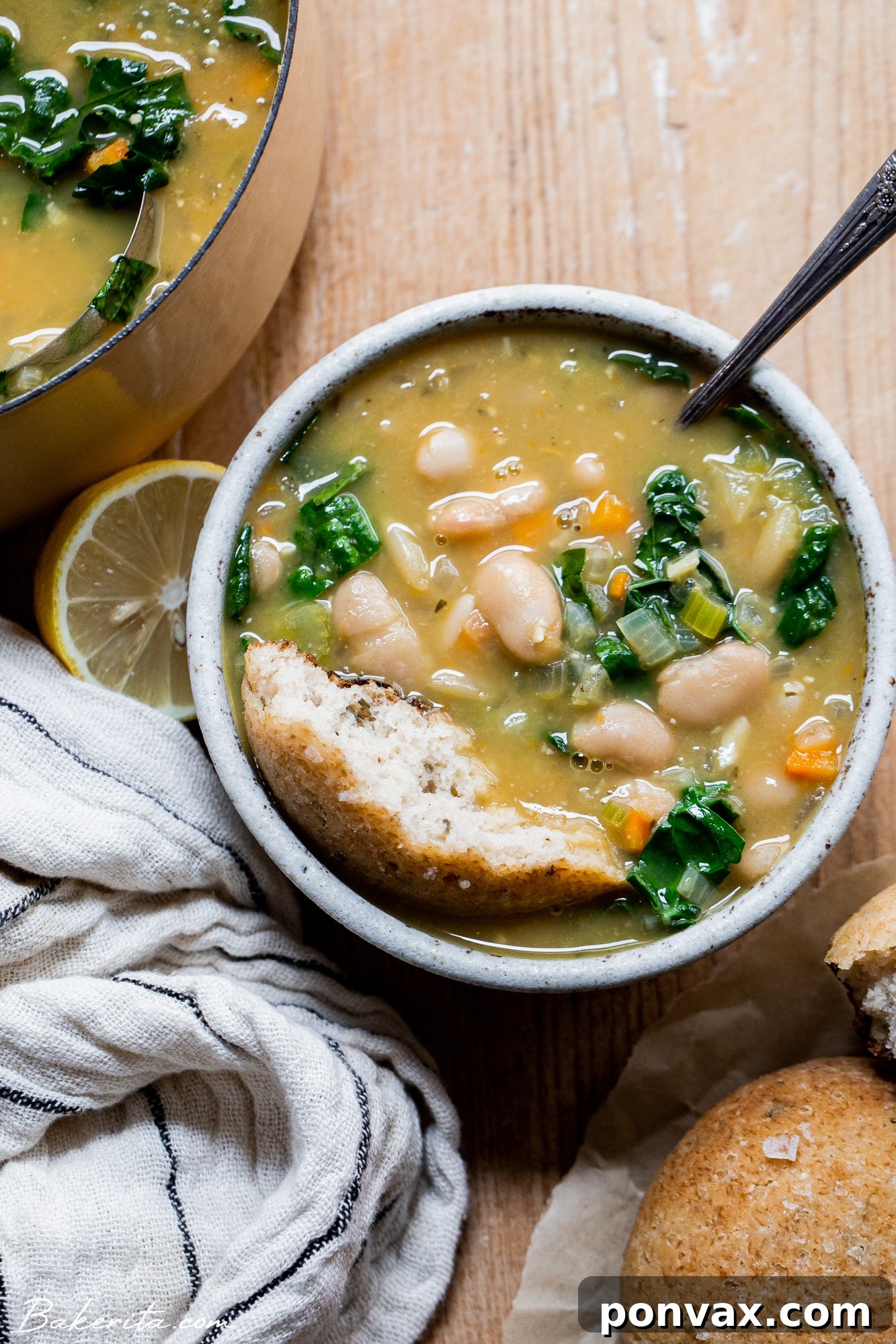 Hearty Vegan Kale and White Bean Soup 3 Close-up of creamy vegan kale and white bean soup with a spoon.