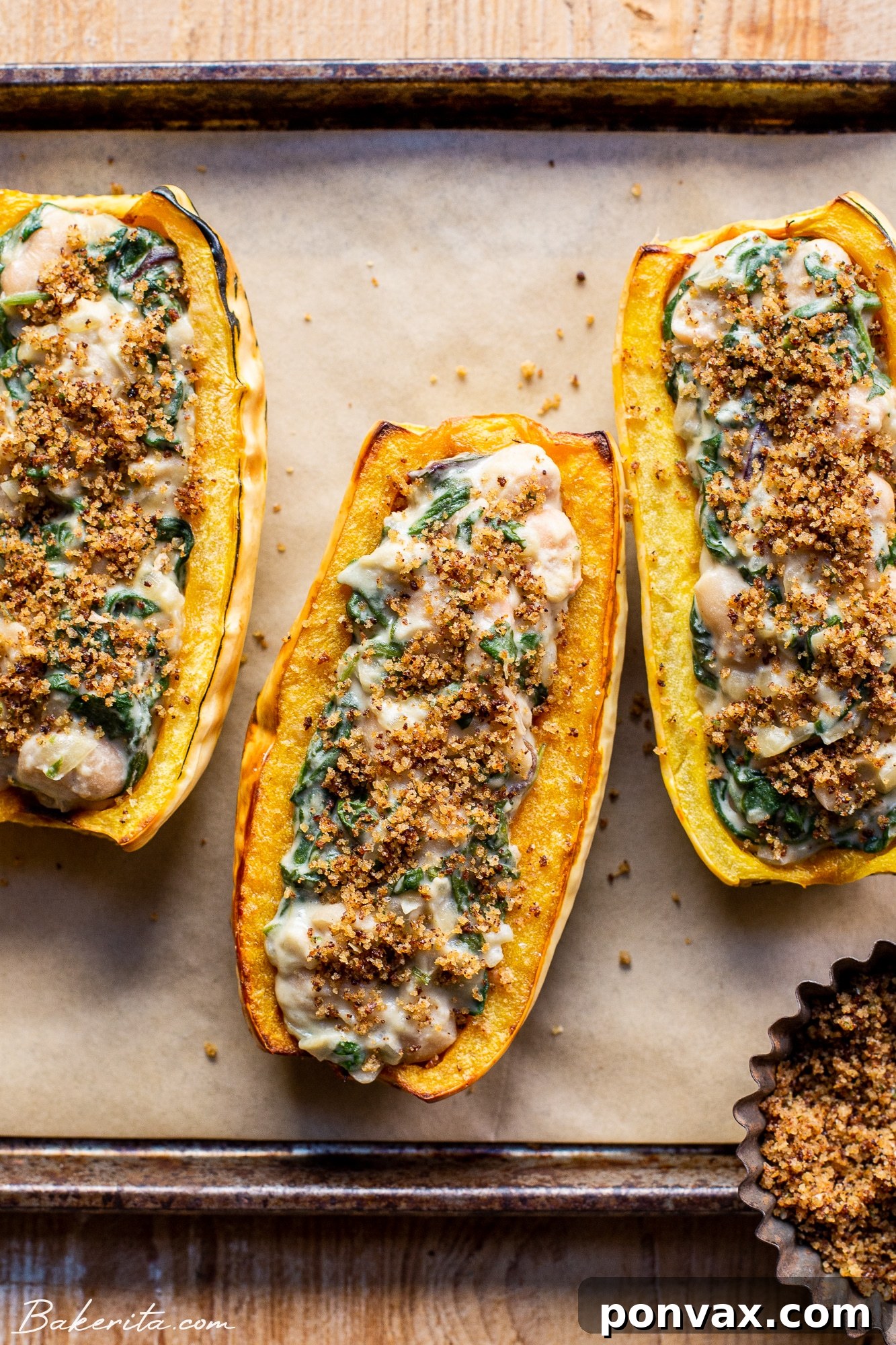 Close-up of a beautifully roasted and stuffed delicata squash, showing the creamy spinach and white bean filling.