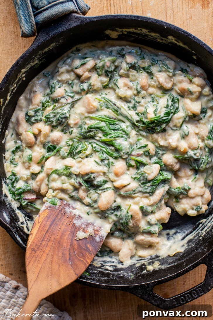 One half of a raw delicata squash, showing the seeds and stringy bits scooped out, ready for roasting.
