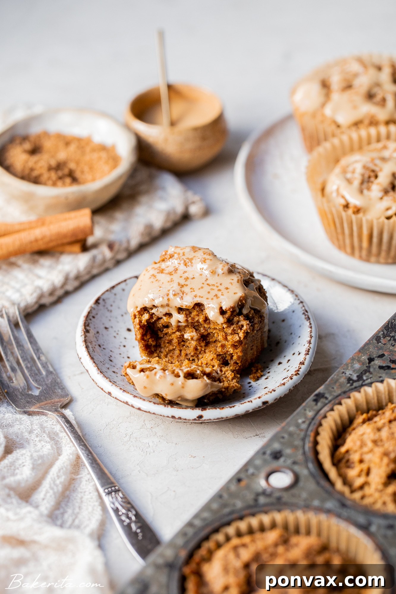 A close-up of a Gluten-Free Chai Muffin, showcasing its crunchy sugared top and tender crumb, resting on a white baking rack.