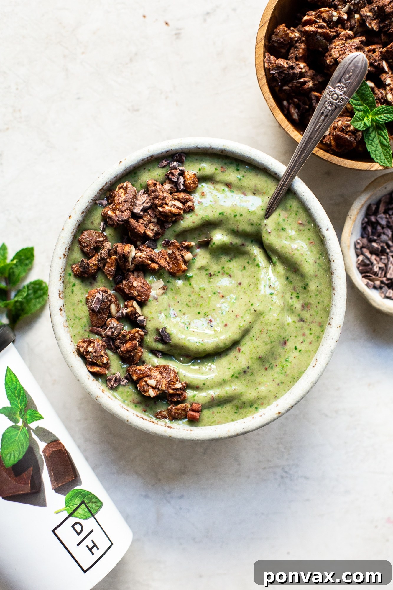 A vibrant mint chip smoothie bowl, topped with fresh berries, coconut flakes, and cacao nibs, ready to be enjoyed.