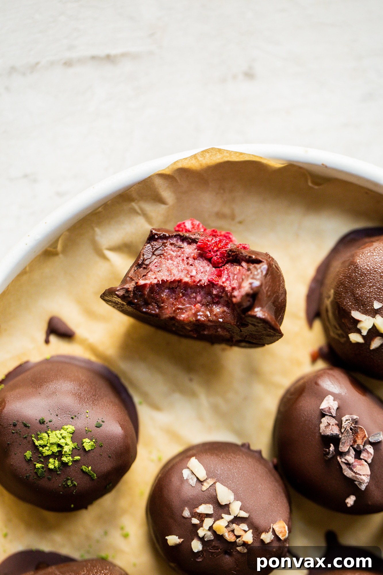 Close-up of a chocolate-covered Daily Harvest bite with flaky sea salt topping, showcasing its decadent appeal.