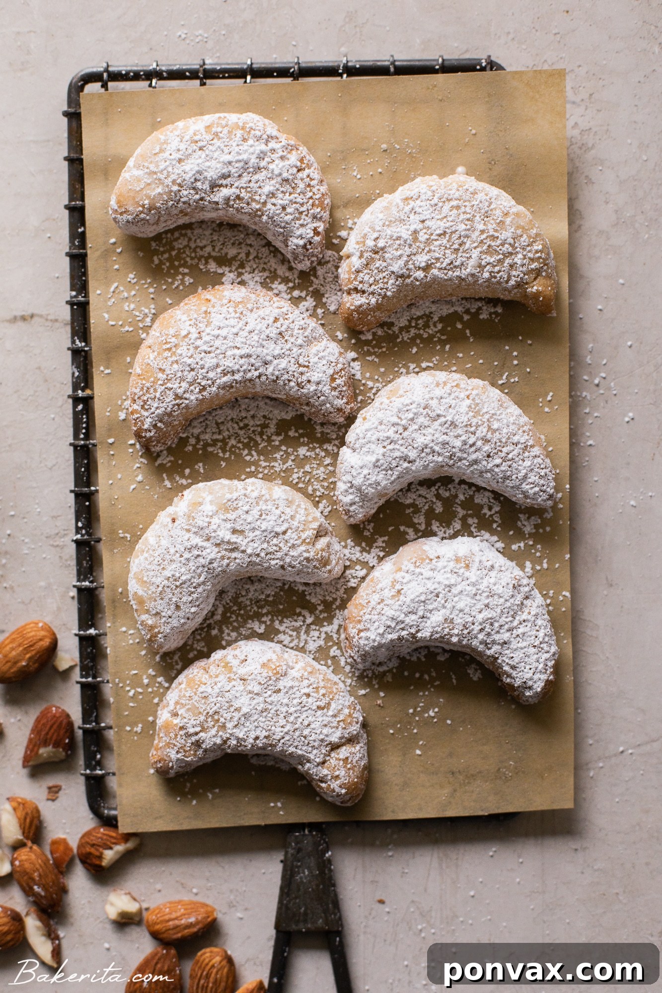 A stack of Vegan Almond Crescent Cookies covered in powdered sugar, ready to be served.