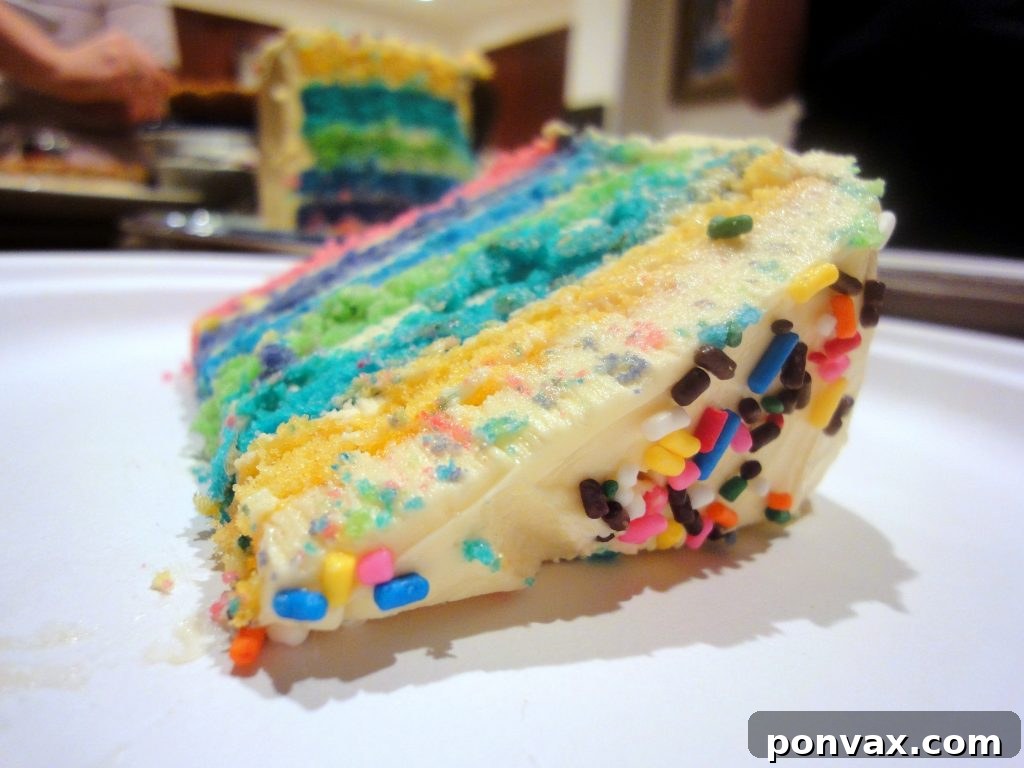 The ultimate six-layer rainbow cake for any celebration A beautifully sliced six-layer rainbow cake revealing its vibrant, colorful layers, set against a festive background, perfect for a birthday celebration.