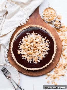 This Dark Chocolate, Coconut & Macadamia Nut Tart is decadent, delicious and easy to make. It has a coconut crust that's filled with a luscious chocolate ganache and topped with toasted coconut and macadamia nuts. You'd never guess that this nutty tart is gluten-free, vegan, Paleo, and refined sugar-free!