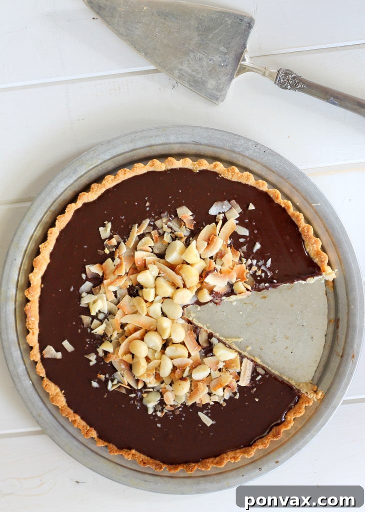 This Dark Chocolate, Coconut & Macadamia Nut Tart is decadent, delicious and easy to make. It has a coconut crust that's filled with a luscious chocolate ganache and topped with toasted coconut and macadamia nuts. You'd never guess that this nutty tart is gluten-free, vegan, Paleo, and refined sugar-free!
