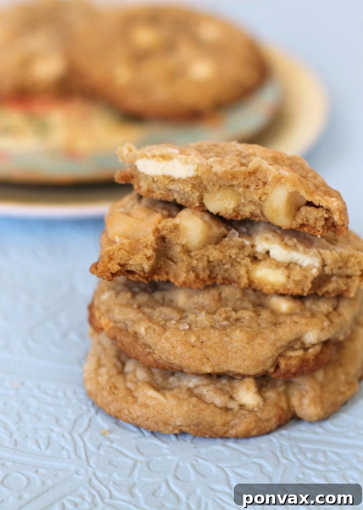 Irresistible White Chocolate Macadamia Nut Cookies A plate of freshly baked, golden-brown White Chocolate Macadamia Nut Cookies, showcasing their delightful texture and generous inclusions.