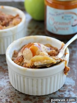 Close-up of a rustic Caramel Apple Crumble in a baking dish, with a spoonful ready to be served.