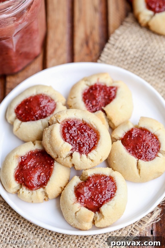 Simple & Sweet: Gluten-Free Vegan Jam Thumbprint Cookies 3 A close-up shot of Gluten-free and vegan Thumbprint Cookies on a white plate, showcasing the rich strawberry rhubarb chia jam filling.