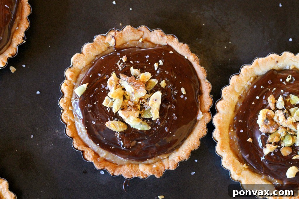 Chocolate Date Caramel Tarts with a cookie-like almond flour and coconut oil crust. This decadent paleo, gluten-free, and vegan treat is free of refined sugar. #vegantart #glutenfree #paleodessert #tartrecipe