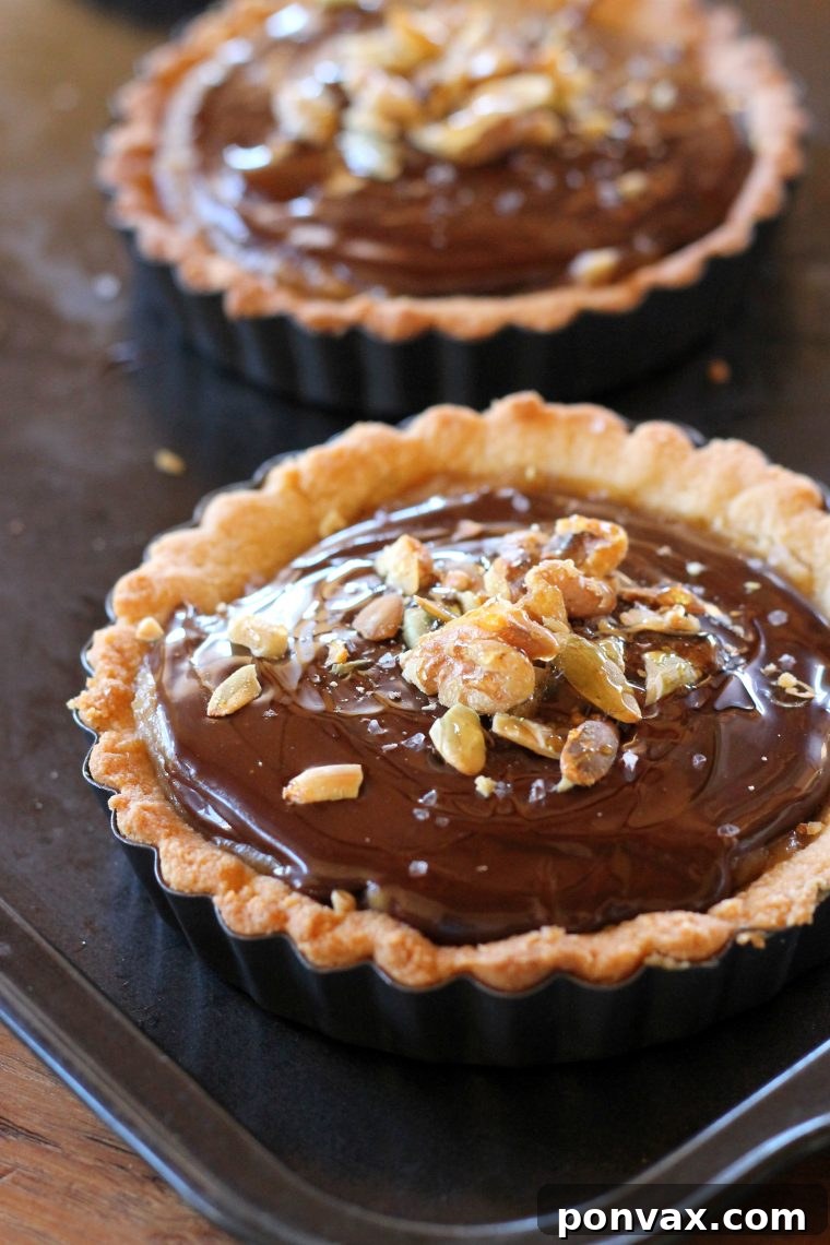 Chocolate Date Caramel Tarts showcase a healthy, rich date caramel filling and a crumbly almond flour crust, perfect for paleo, gluten-free, and vegan diets. #vegantart #glutenfree #paleodessert #tartrecipe