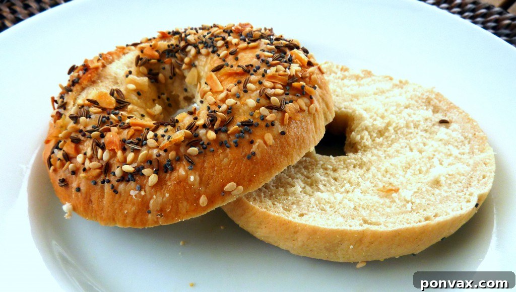Freshly baked homemade everything bagels cooling on a wire rack, sprinkled with savory seasoning.