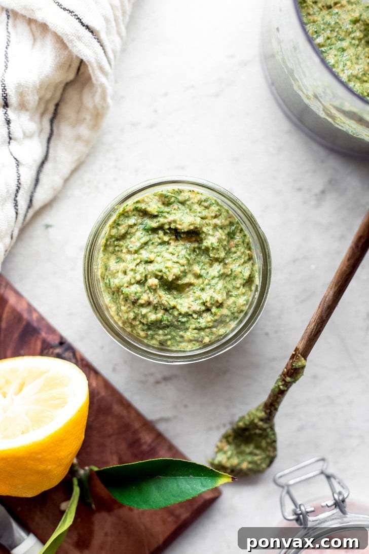 Vibrant green fennel frond pesto in a bowl with a spoon