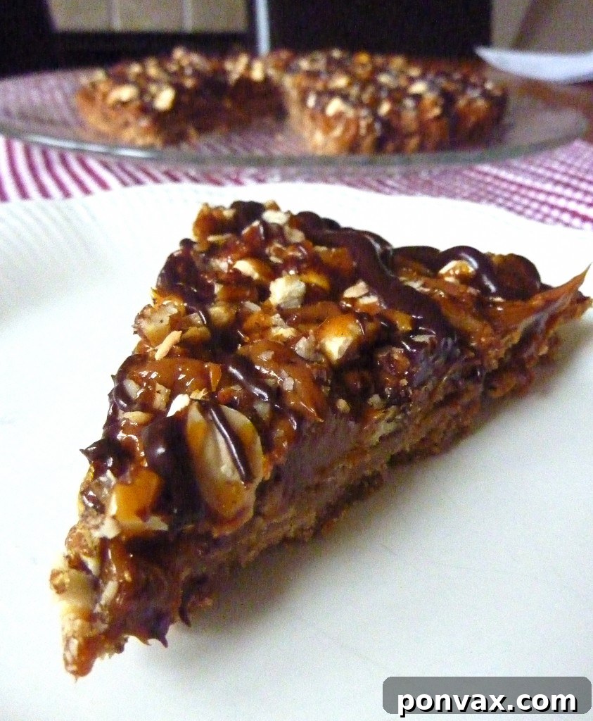 A stunning Browned Butter Dulce De Leche Tart with a shortbread crust, creamy dulce de leche, crunchy candied nuts, and a delicate chocolate drizzle, ready to be served.