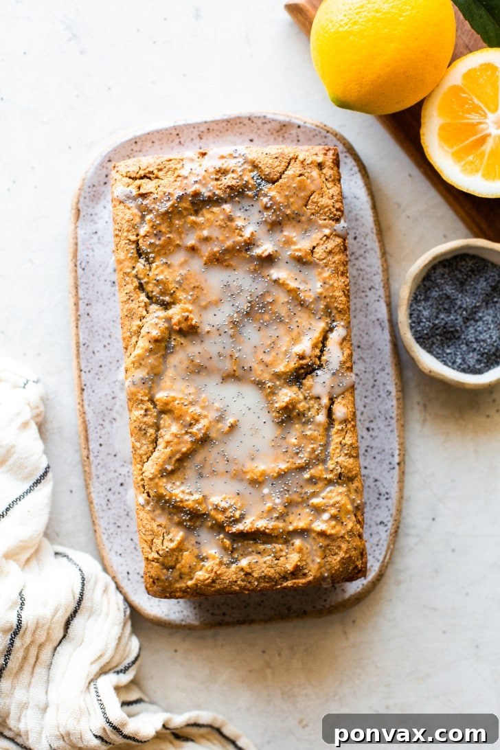 Zesty Gluten-Free Lemon Poppyseed Loaf 3 Whole Gluten-Free Lemon Poppyseed Loaf Cake on a cooling rack, drizzled with lemon glaze.