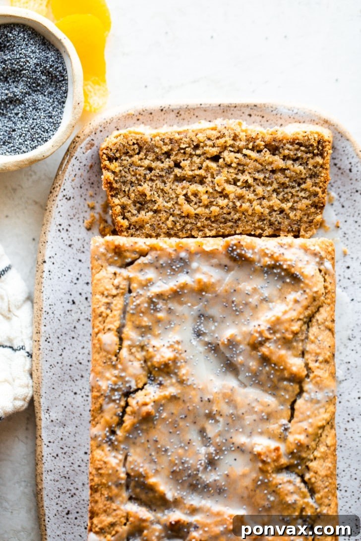 Zesty Gluten-Free Lemon Poppyseed Loaf 4 Close-up of a slice of Gluten-Free Lemon Poppyseed Loaf Cake, showing the moist crumb and poppy seeds.