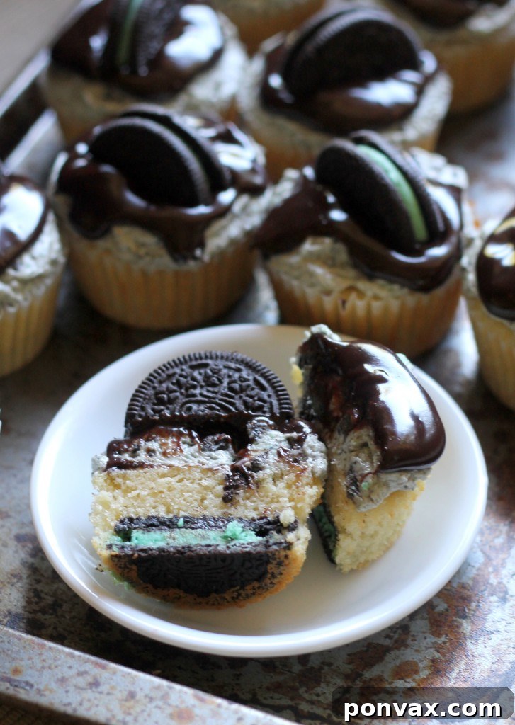 Delicious Mint Cookies & Cream Cupcakes with chocolate ganache and Mint Oreo halves on top, featuring a vanilla cupcake and Mint Oreo buttercream.