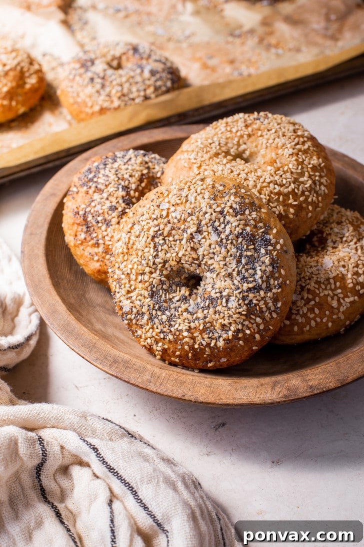 A stack of freshly baked gluten-free sourdough bagels, perfectly golden and ready to be sliced and topped.