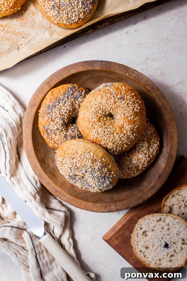 A baker shaping gluten-free sourdough bagel dough into a round with a hole in the center.