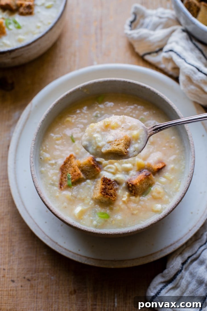 Golden Vegan Corn Chowder 7 A bowl of Vegan Corn Chowder ready to be served, garnished with herbs.