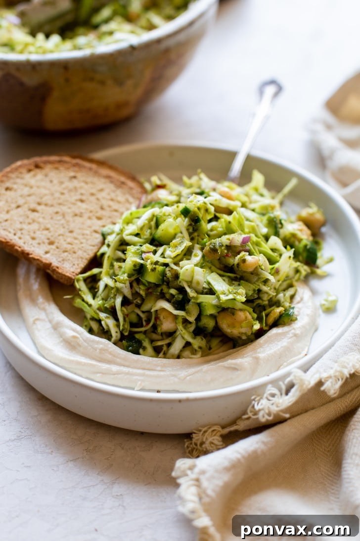 Vibrant Five Ingredient Chimichurri Chickpea Salad 5 A hand holding a fork with a spoonful of the 5-Ingredient Chickpea Chimichurri Salad, ready for a bite.