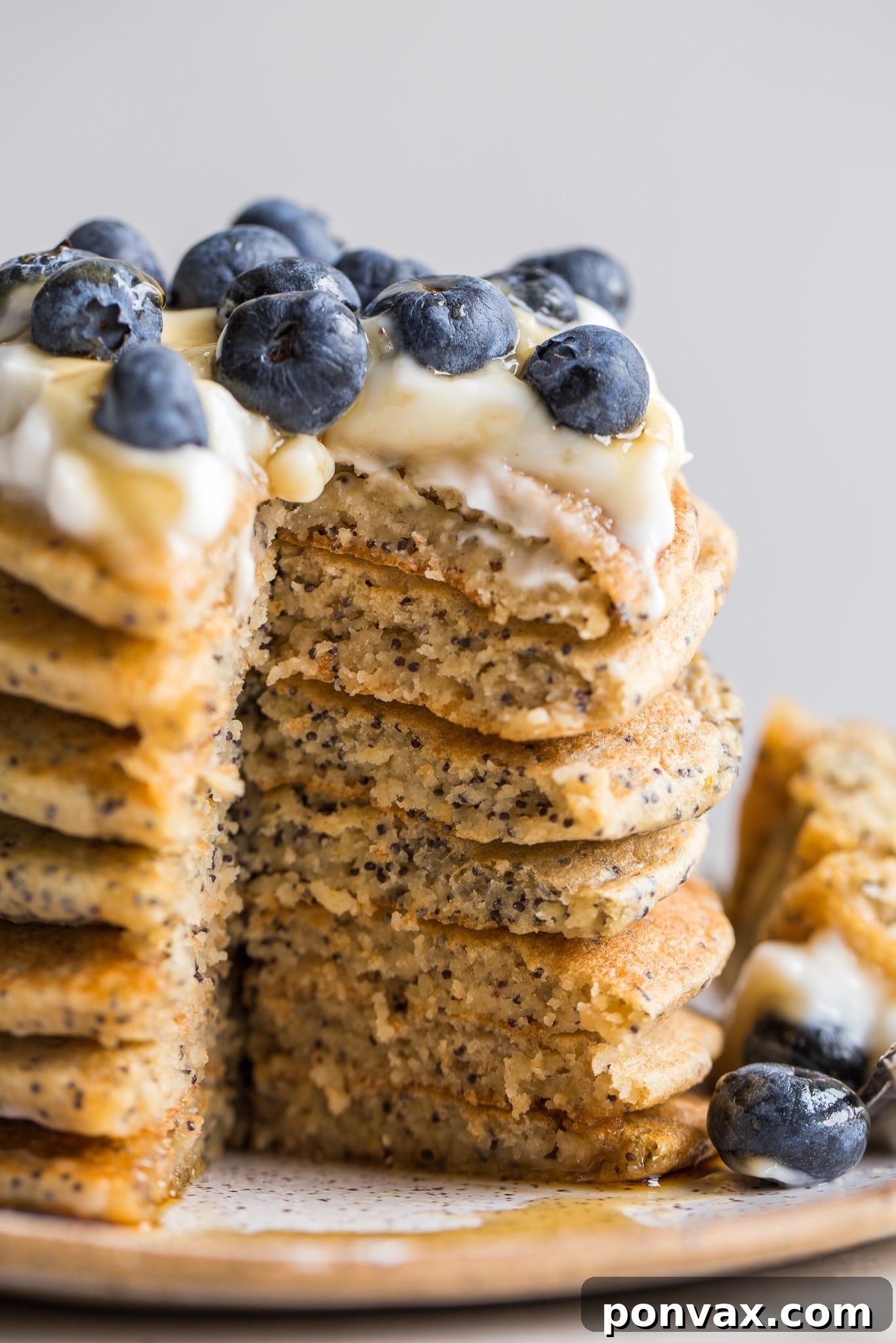 Overhead shot of a plate of Vegan Lemon Poppyseed Pancakes garnished with fresh berries.