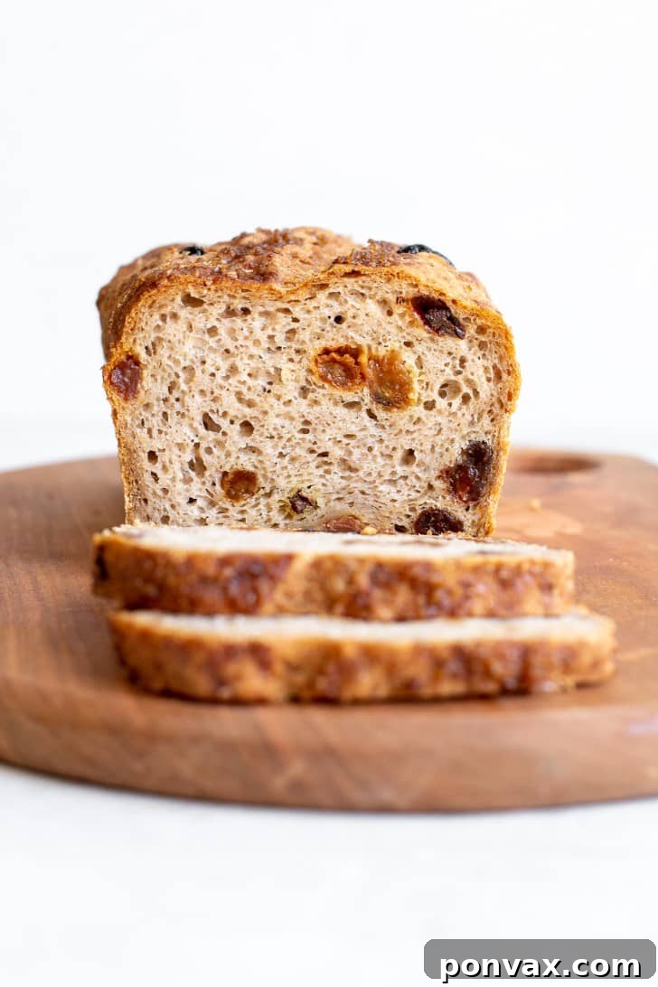 Freshly baked Gluten-Free Cinnamon Raisin Bread, sliced to show its fluffy interior and abundance of raisins.