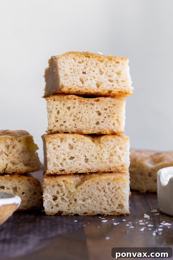Effortless Gluten-Free Focaccia 2 Golden brown gluten-free focaccia bread garnished with sliced shallots and fresh rosemary, drizzled with olive oil.