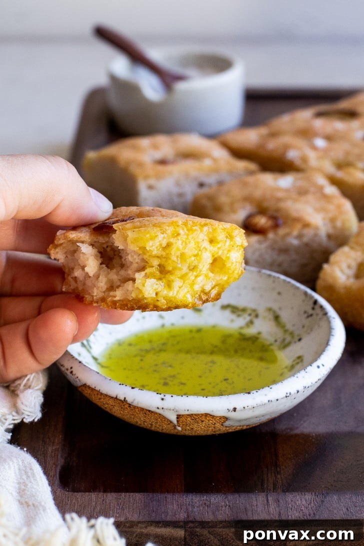 Effortless Gluten-Free Focaccia 15 A serving of freshly baked gluten-free focaccia on a rustic wooden board, ready to be enjoyed.