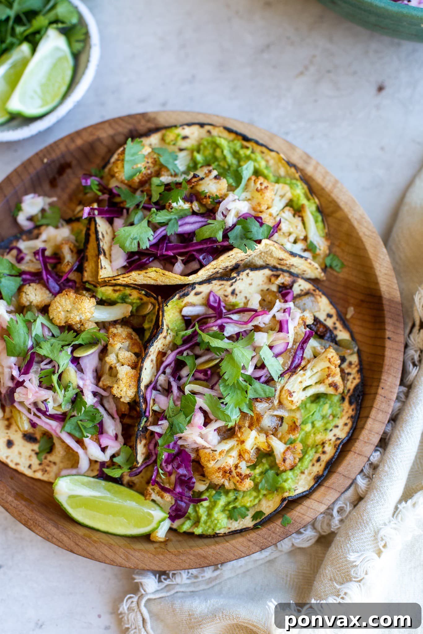 Zesty Roasted Cauliflower Tacos with Tangy Cabbage Slaw 5 Two hands holding a Vegan Roasted Cauliflower Taco, showing the filling and fresh toppings.