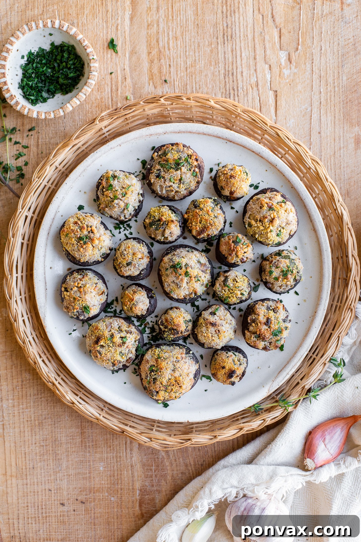 Savory Vegan Mushroom Bites 4 Two hands holding a freshly baked vegan stuffed mushroom, showing its golden-brown top.