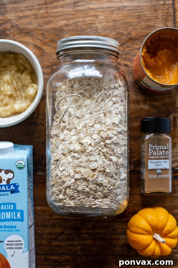 The five core ingredients for Easy Pumpkin Oatmeal: pumpkin puree, rolled oats, a ripe banana, dairy-free milk, and pumpkin pie spice.