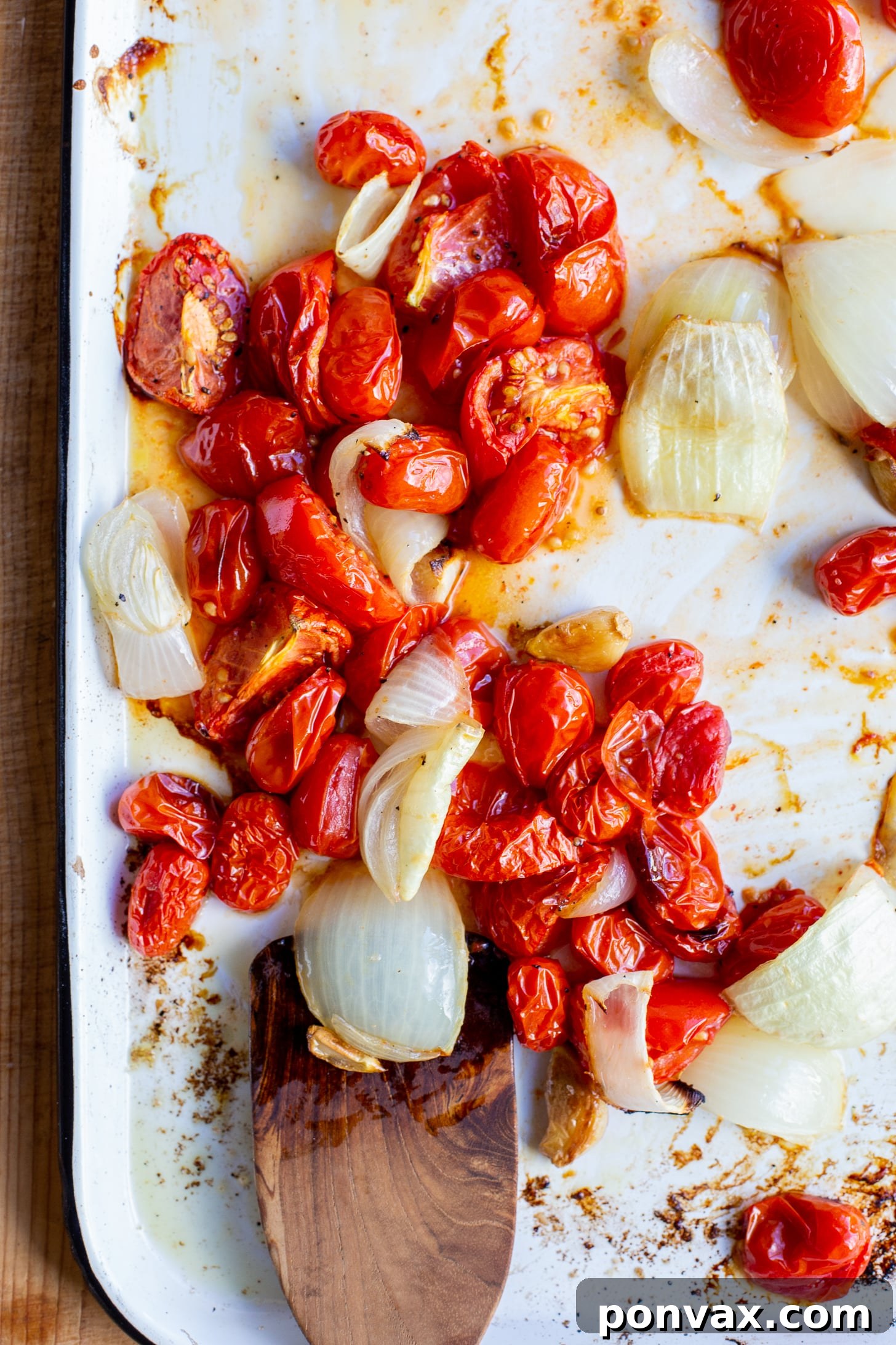 Sun Kissed Roasted Tomato and Chickpea Comfort 6 Perfectly golden-brown roasted tomatoes, onions, and garlic on a white sheet pan, having achieved optimal caramelization.