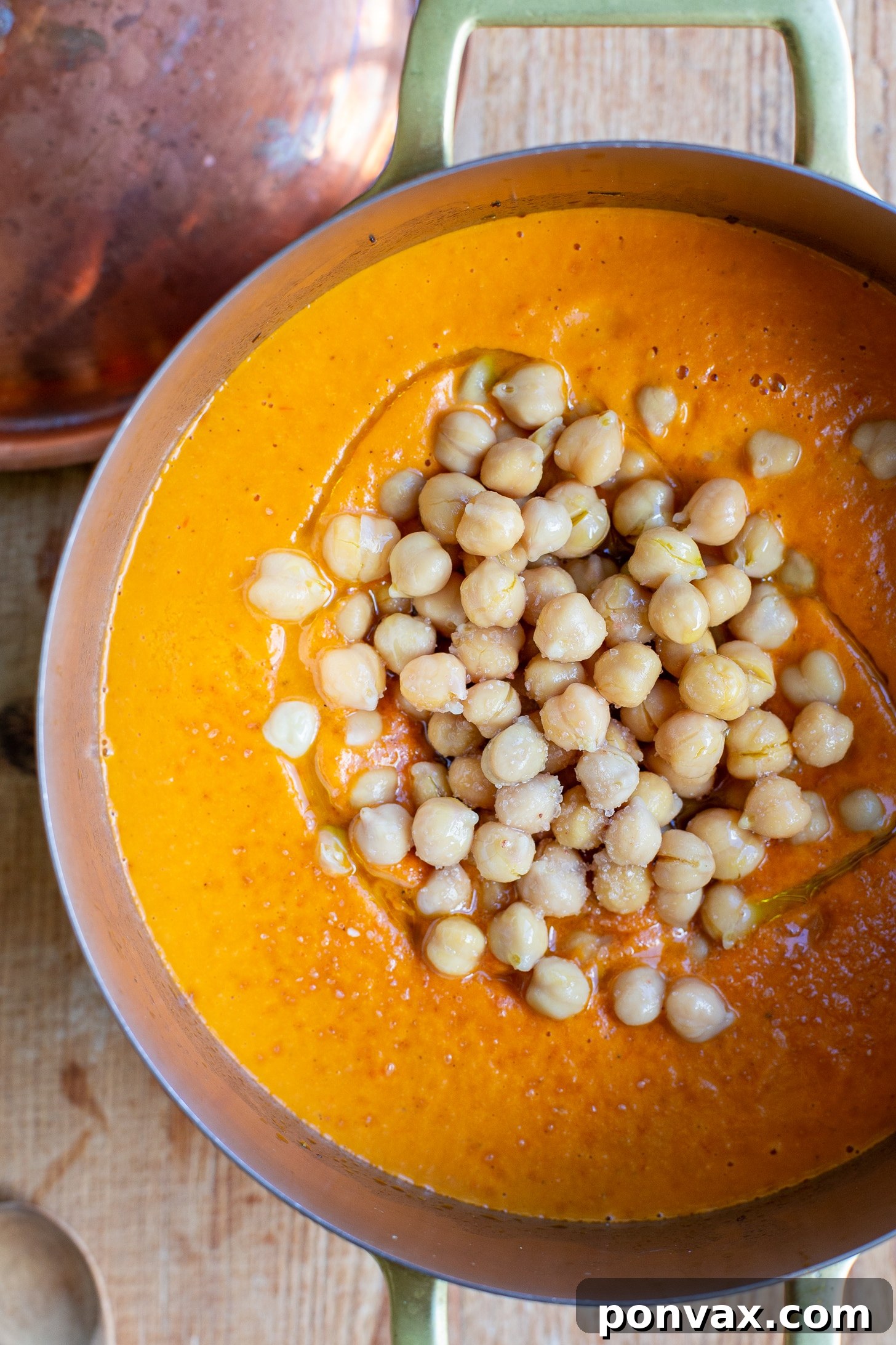 Sun Kissed Roasted Tomato and Chickpea Comfort 8 Close-up of vibrant roasted tomato chickpea soup simmering in a pot, ready to be served.