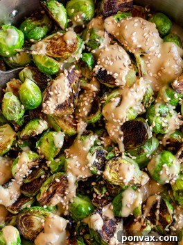 Delicious Miso Sesame Brussels Sprouts ready to be served in a bowl, garnished with green onions.