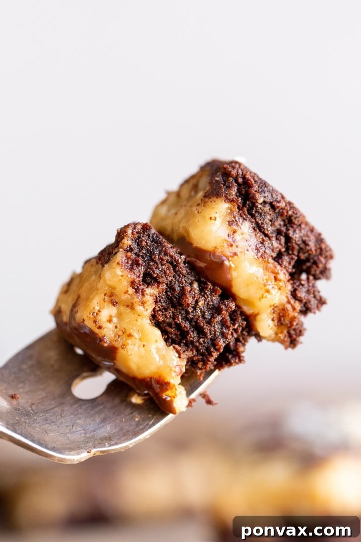 Decadent Gluten-Free Coconut Caramel Brownies 11 Two hands holding a piece of Gluten-Free Coconut Caramel Brownie, showing the delicious layers.