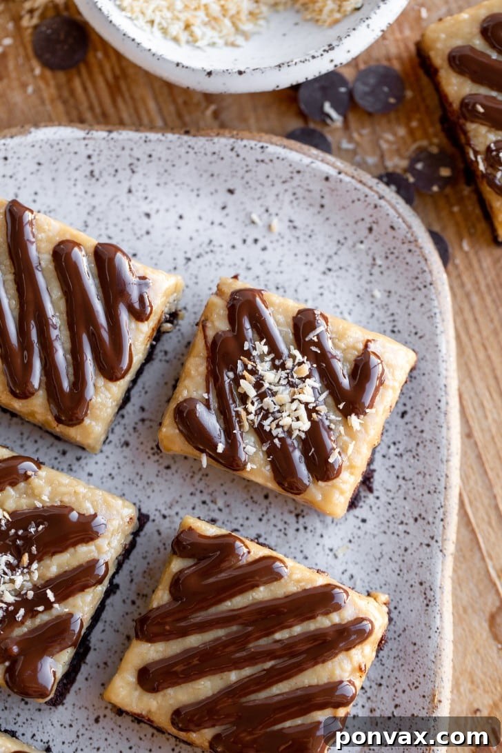 Decadent Gluten-Free Coconut Caramel Brownies 3 Close-up of a stack of fudgy Gluten-Free Coconut Caramel Brownies, showing the rich chocolate base, golden coconut caramel, and chocolate drizzle.