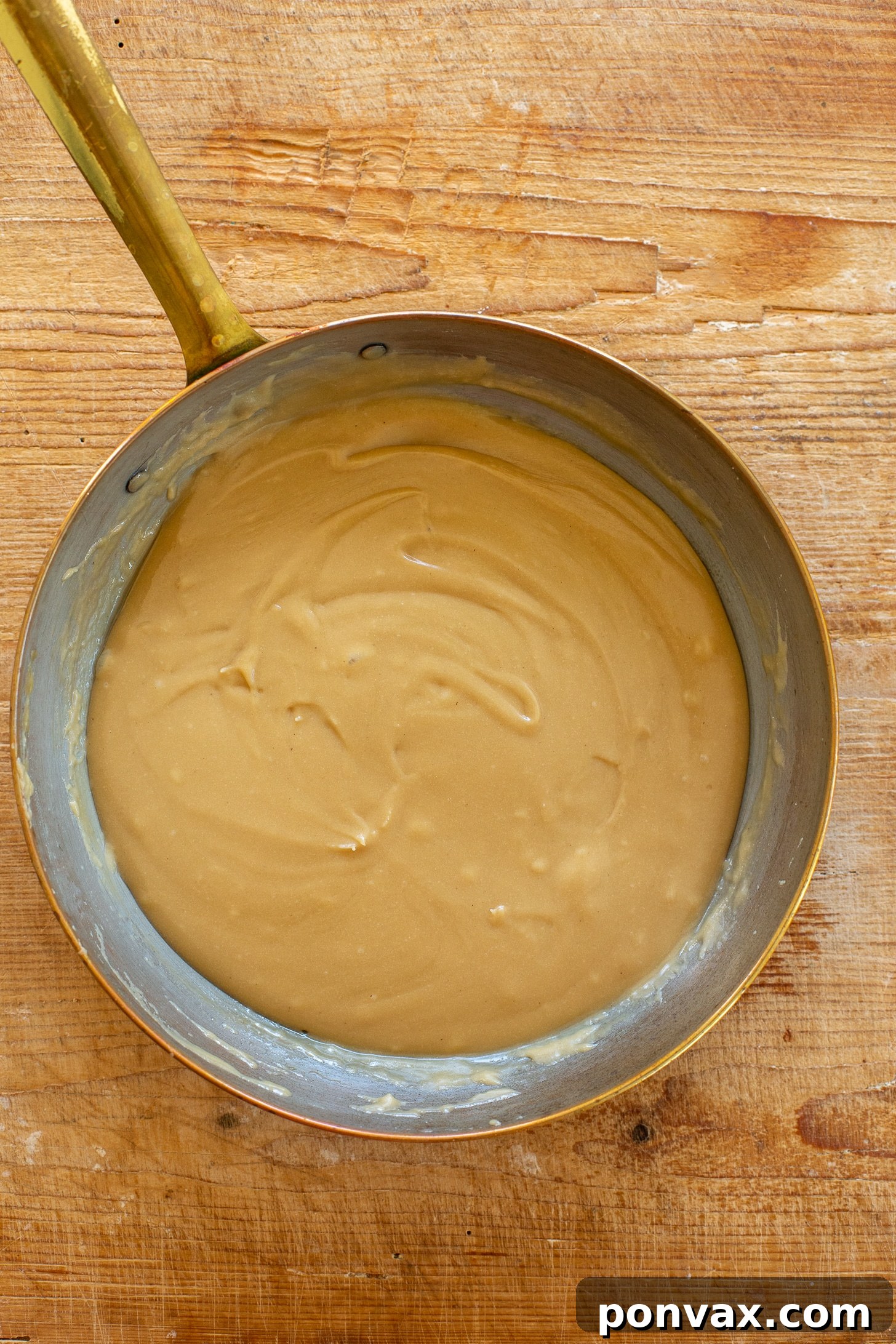 Decadent Gluten-Free Coconut Caramel Brownies 5 Brownie batter being spread into a parchment-lined baking pan.