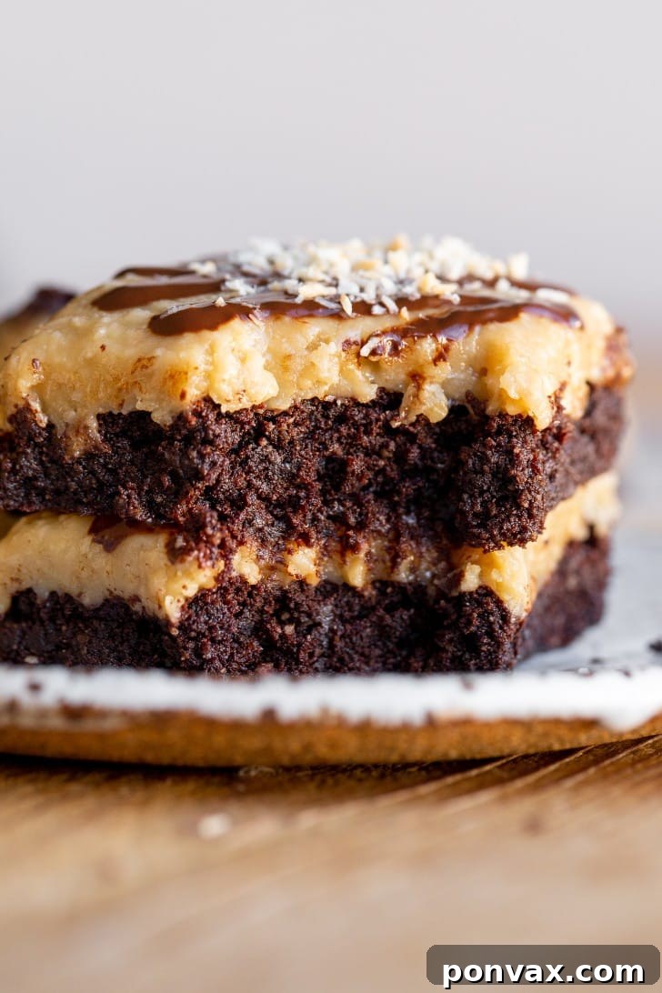 Decadent Gluten-Free Coconut Caramel Brownies 10 A single gluten-free coconut caramel brownie on a white plate, highlighting the layers and chocolate drizzle.