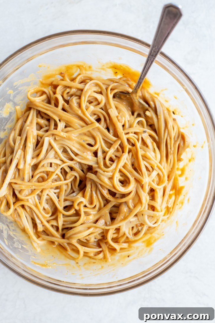 Velvety Peanut Noodles in 5 Minutes 11 Noodles being tossed with the peanut sauce.