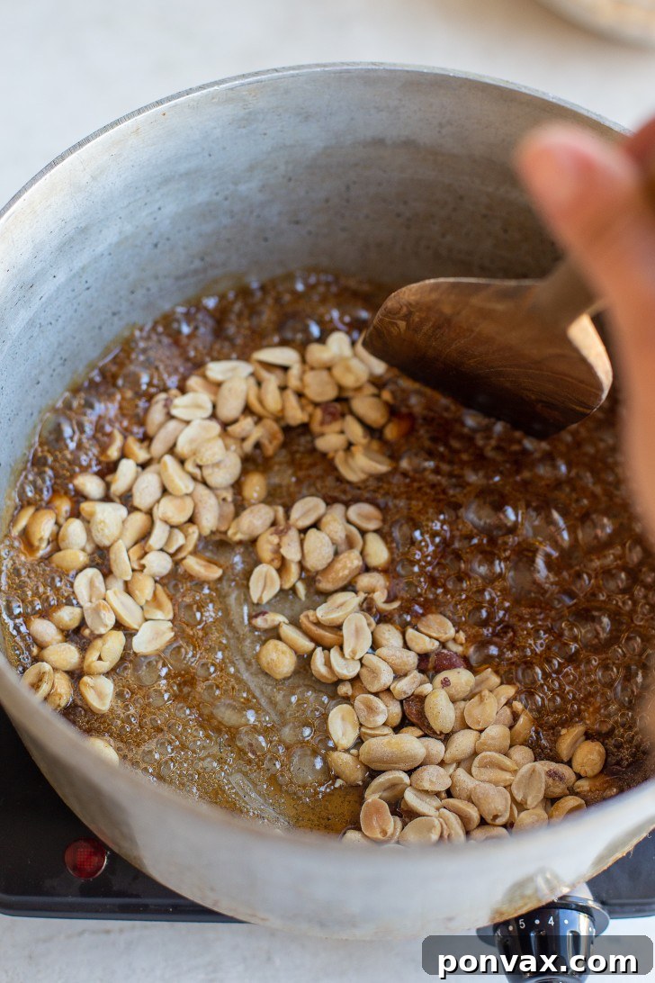 Spices and vanilla extract being added to simmering maple syrup