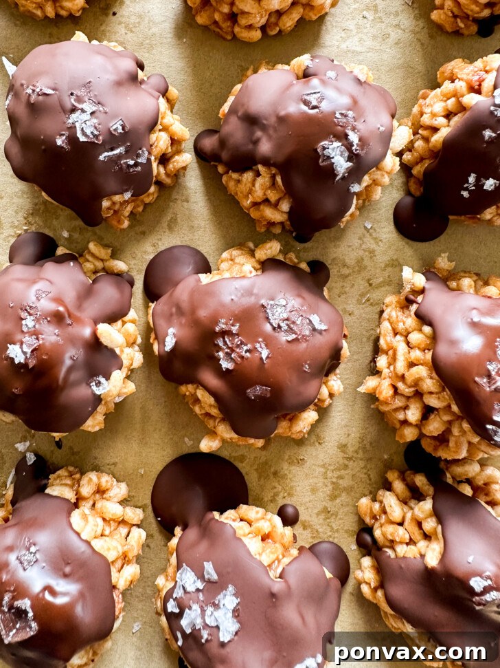 Crispy Chocolate Peanut Butter Treats arranged on parchment paper, ready to be devoured.