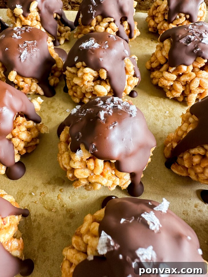 Close-up of freshly made Crispy Chocolate Peanut Butter Treats on parchment paper.