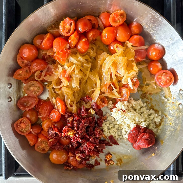 Velvety Tomato and Cannellini Stew 8 Garlic and sun-dried tomatoes being added to the stew.