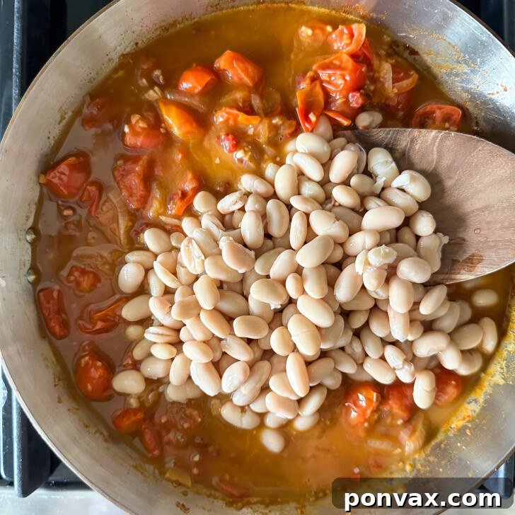 Velvety Tomato and Cannellini Stew 10 Broth and white beans simmering in the pan.
